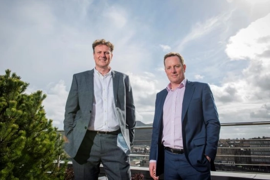 Image of two men standing together on a roof terrace